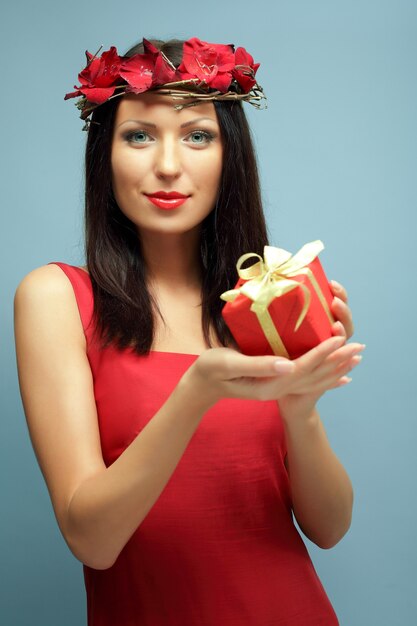 Schöne Frau mit rotem Geschenk, Mode und Leidenschaft