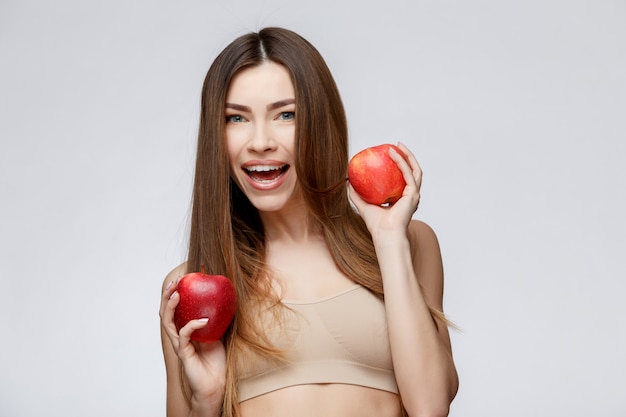 Schöne Frau mit sauberer frischer Haut, die Apfel hält