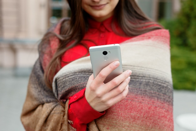 Schöne Frau mit Smartphone-Technologie-App in den Straßen der Stadt, die einen urbanen, glücklichen Lebensstil lebt. Geschäftsfrau, die die Nachricht auf ihrem Telefon antippt