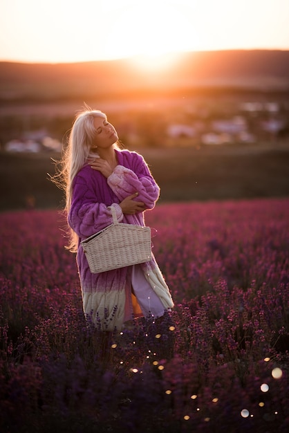 Schöne Frau mit stilvoller Strickjacke posiert in Lavendel