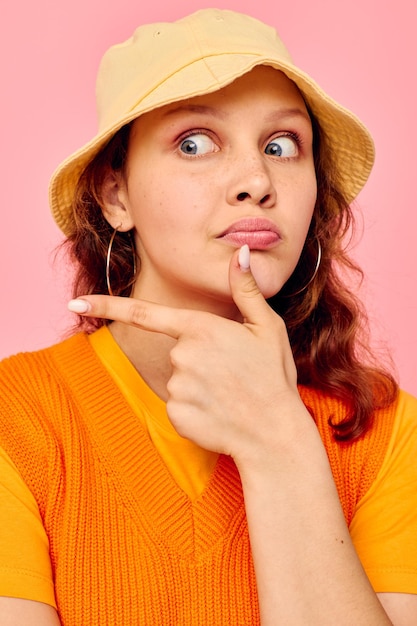 schöne frau orange pullover gefühle spaß rosa hintergrund unverändert. Foto in hoher Qualität