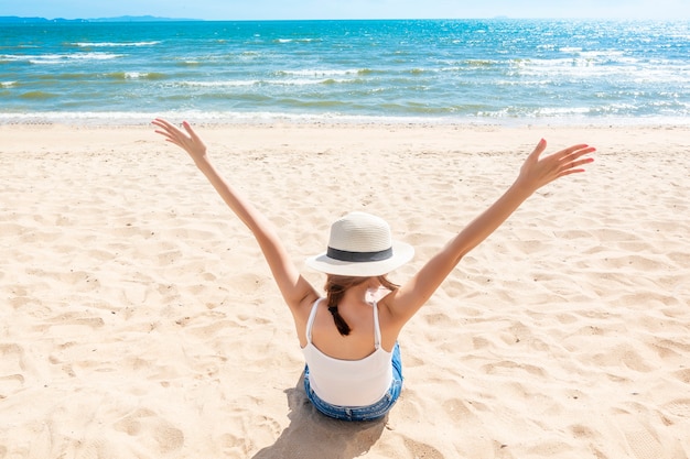 Schöne Frau sitzt am Strand