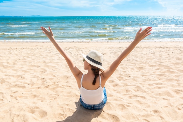 Schöne Frau sitzt am Strand