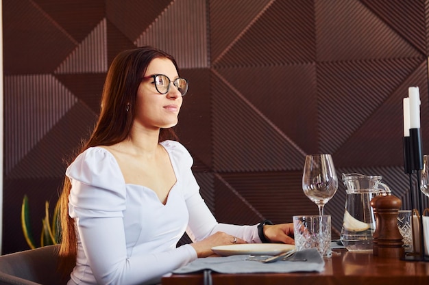 Schöne Frau sitzt am Tisch Innenbereich des neuen modernen Luxusrestaurants