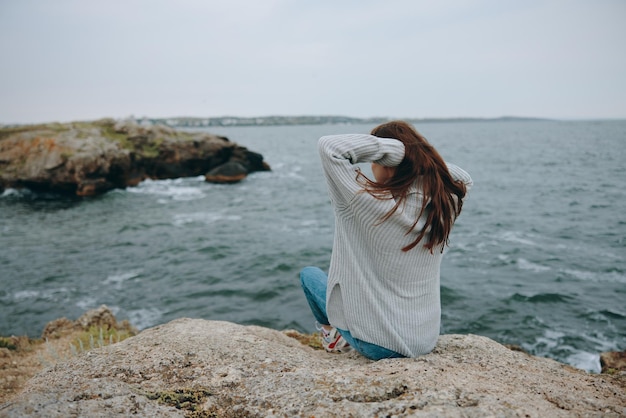 Schöne Frau sitzt auf der Küste Pullover Landschaft unverändert