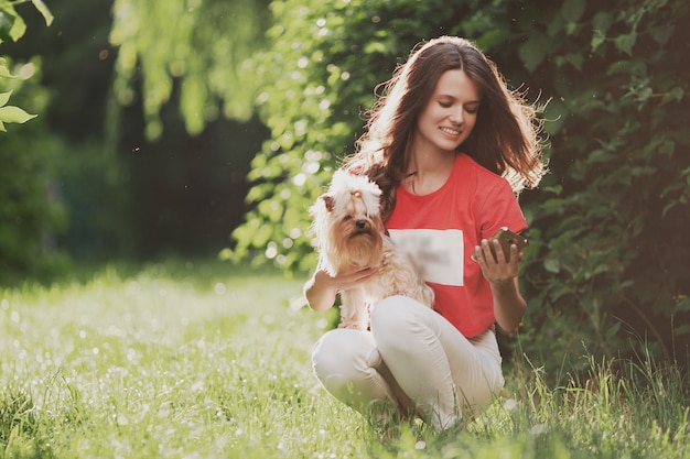 Schöne Frau spielen mit Hund im Park