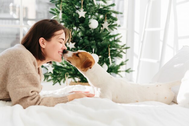 Schöne Frau und Hund haben süßen Kuss, fühlen sich miteinander lieben