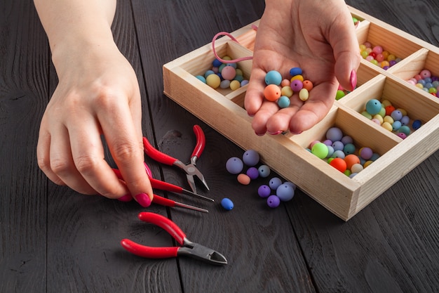 Schöne Frauen am Tisch machen Schmuck