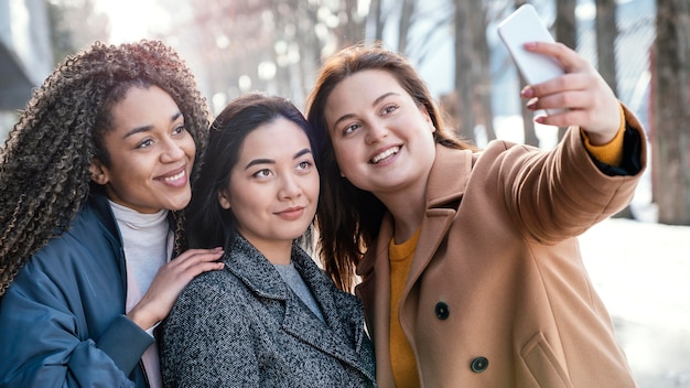 Foto schöne frauen, die zusammen posieren, während sie selfie nehmen