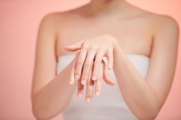 Schöne Frauenhände isolieren das Auftragen der Crememassage