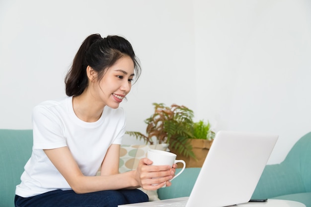 Schöne freiberufliche Frau, die auf Videokonferenz online mit Laptop zu Hause spricht