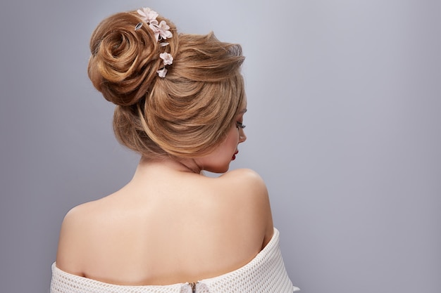 Schöne Frisur auf blondem Haar mit Blumenschmuck