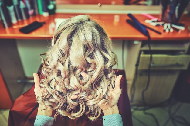 Schöne Frisur der jungen Frau nach dem Sterben der Haare und dem Hervorheben von Highlights im Friseursalon.