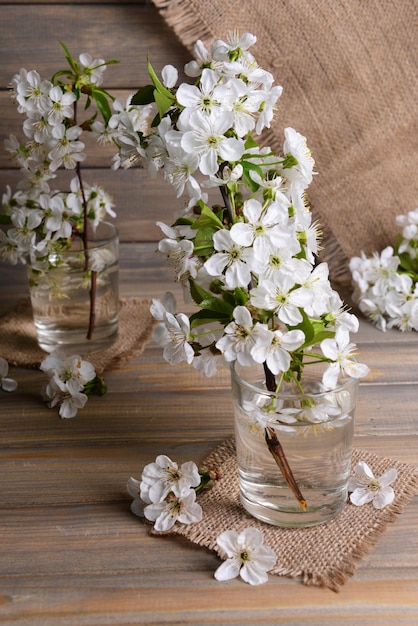 Schöne Fruchtblüte im Glas auf dem Tisch auf grauem Hintergrund