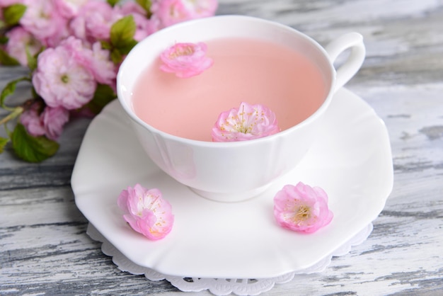 Foto schöne fruchtblüte mit einer tasse tee auf dem tisch in der nähe