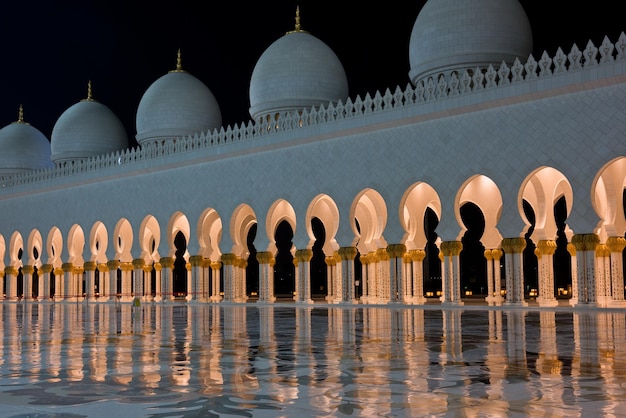 Schöne Galerie der berühmten Sheikh Zayed White Moschee in Abu Dhabi, Vereinigte Arabische Emirate bei Nacht