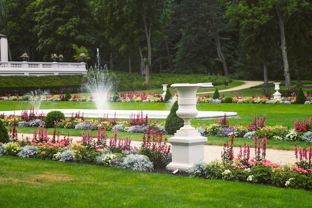 Schöne Gasse im Park mit Blumen und Vasen geschmückt