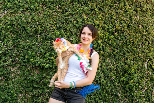 Schöne gelbe Katze und Frau des brasilianischen Haustierkarnevals im Karnevalskostüm