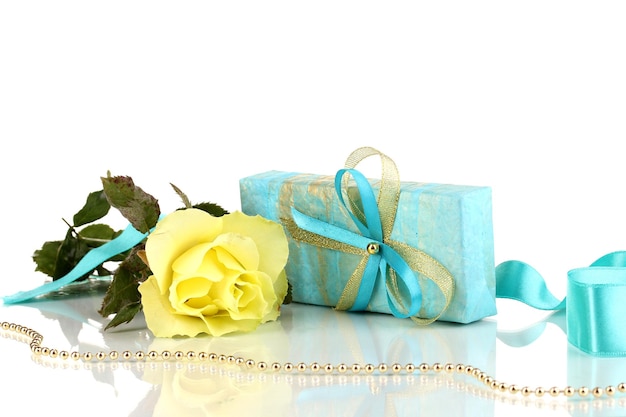 Schöne gelbe Rose mit wunderbarem Geschenk in blauer Box, isoliert auf weiss