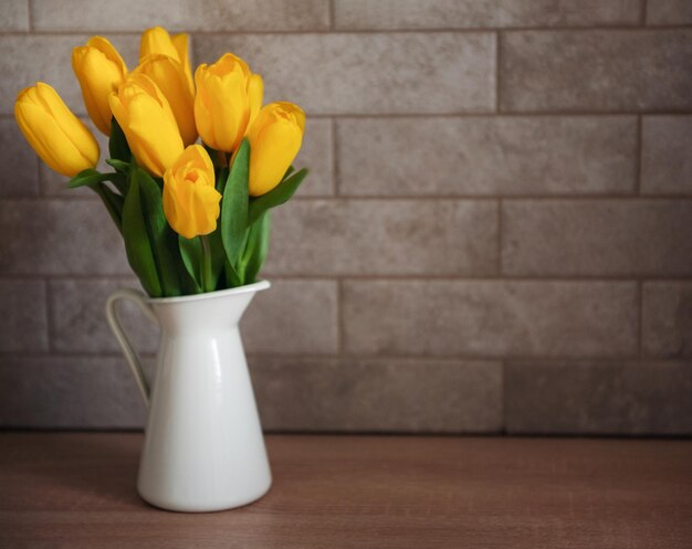 Foto schöne gelbe tulpenblumen auf dem tisch in der küche