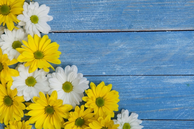 Schöne gelbe und weiße Blumen auf einem Holztisch