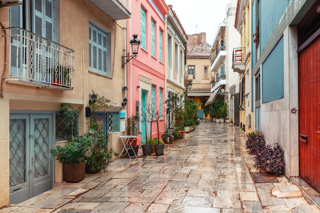 Schöne gemütliche schmale Straße mit Treppen im berühmten Stadtteil Placa am regnerischen Tag, Altstadt von Athen, Griechenland