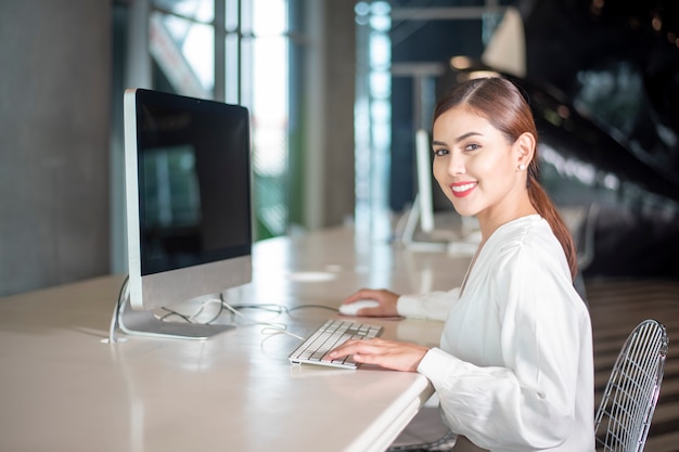 Schöne Geschäftsfrau arbeitet mit ihrem Computer