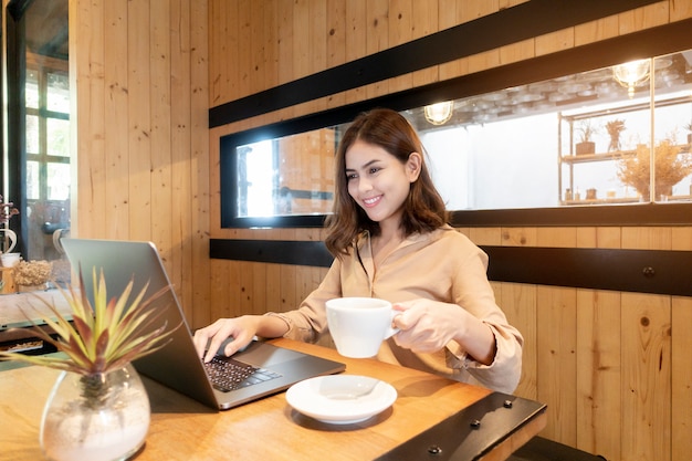 Schöne Geschäftsfrau arbeitet mit ihrem Laptop in der Kaffeestube