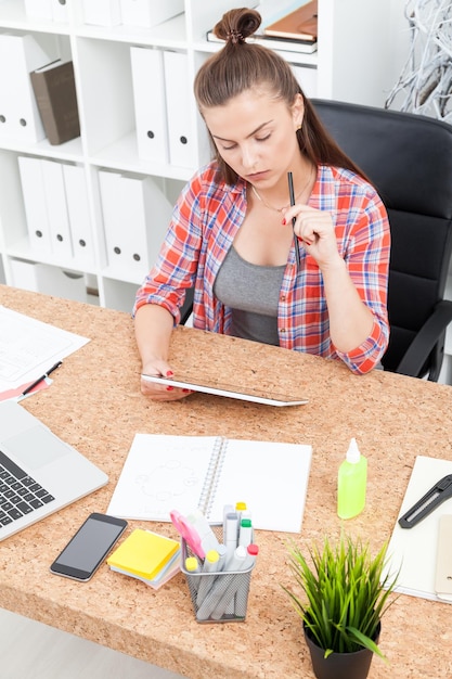 Foto schöne geschäftsfrau, die an ihrem schreibtisch arbeitet