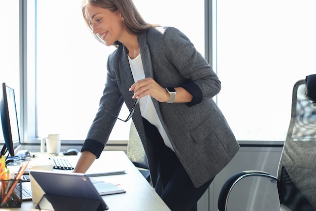 Schöne Geschäftsfrau, die an Laptop im Büro arbeitet.