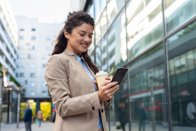 Schöne Geschäftsfrau, die draußen Telefon verwendet