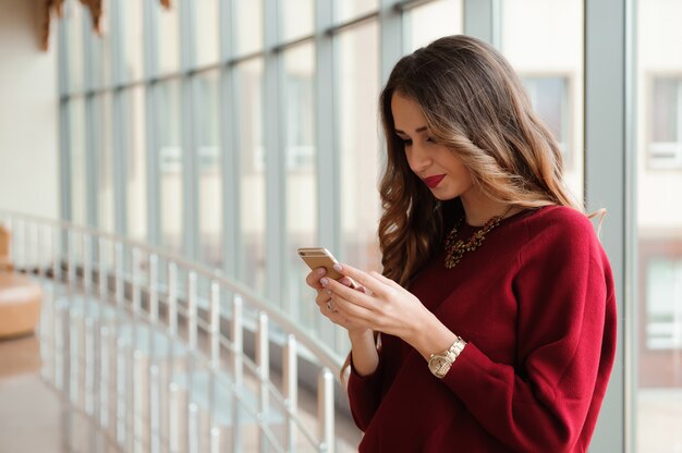 Schöne Geschäftsfrau, die SMS auf einem Handy schreibt