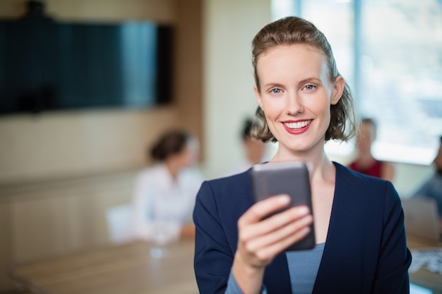 Schöne Geschäftsführerin, die auf ihrem Handy im Konferenzraum spricht