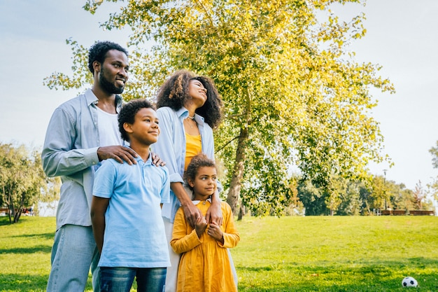 Schöne glückliche afroamerikanische Familienbindung im Park - Schwarze Familie, die Spaß im Freien hat