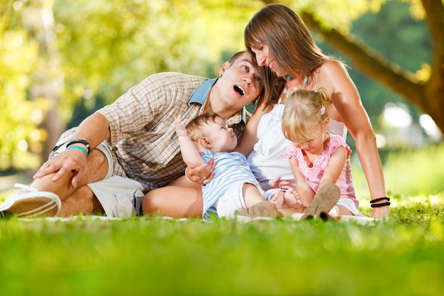 Schöne glückliche Familie, die im Park genießt