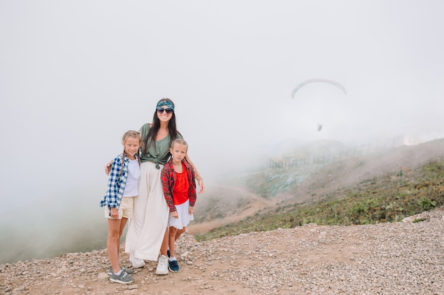 Schöne glückliche Familie in den Bergen im Hintergrund des Nebels. Wunderschöne Landschaft