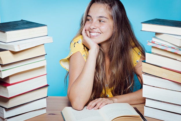 Schöne glückliche junge Frau mit Büchern