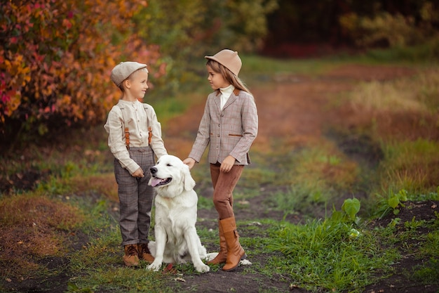 Schöne glückliche Kinder Bruder und Schwester gehen ihren Hund Retriever