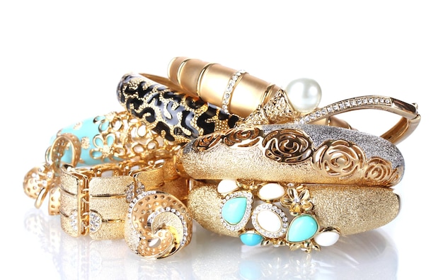 Schöne goldene Armbänder und Ringe, isoliert auf weißem
