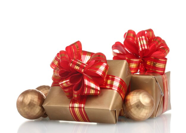 Schöne goldene Geschenke mit rotem Band und Weihnachtskugeln isoliert auf weiß