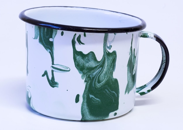 Schöne grüne Emaille-Tasse auf weißem Hintergrund