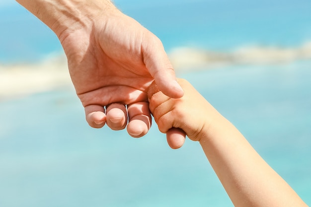 Schöne Hände von Eltern und Kind am Meer