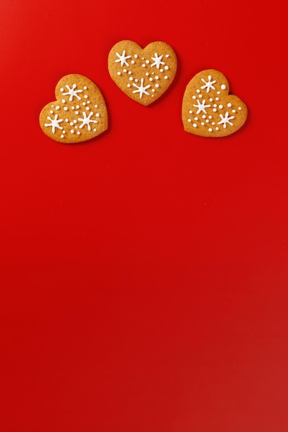 Foto schöne handgebackene kekse in form eines herzens auf rotem hintergrund