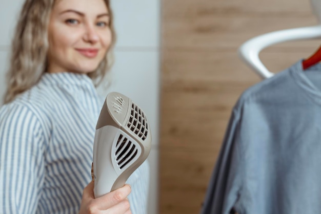 Schöne Hausfrau bügelt ihr Hemd im Haus mit Dampfgarer Wäscherei und chemische Reinigung