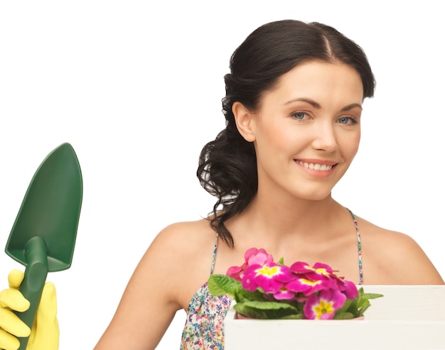 schöne Hausfrau mit Blumenkasten und Gartenkelle