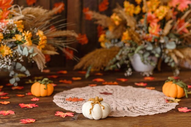 Schöne Herbstfotozone mit bunten Blättern, Trockenblumen und gestrickten Kürbissen