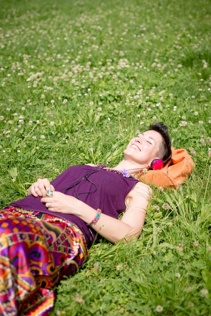 Foto schöne hipster kurze haare frau musik im park hören