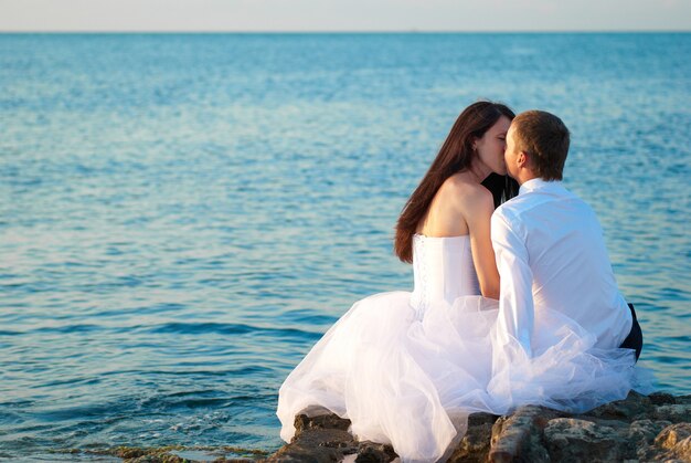 Schöne hochzeitspaar braut und bräutigam küssen am strand