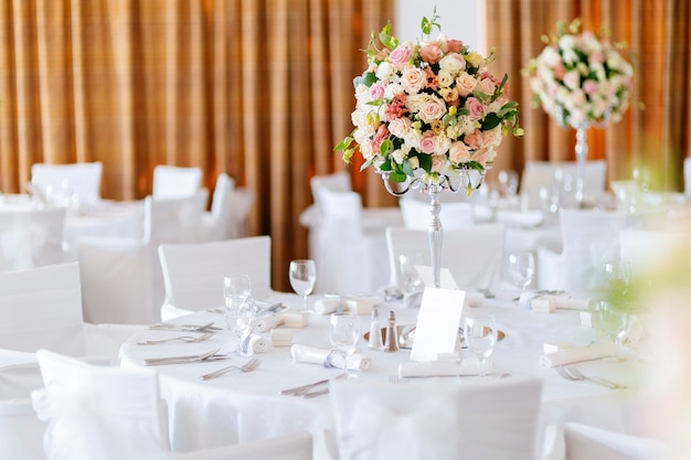 Schöne Hochzeitstische und Rosen im Blumenstrauß