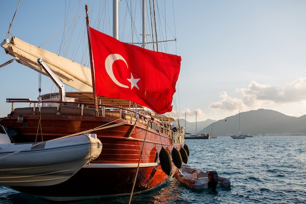 Schöne hölzerne Yacht mit der großen Flagge der Türkei auf dem Pier